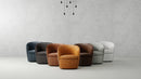 Set of five armchairs in various colors arranged in a row against a plain wall.
